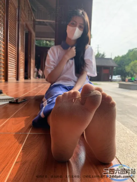 有一个女人坐在地板上，双脚抬起