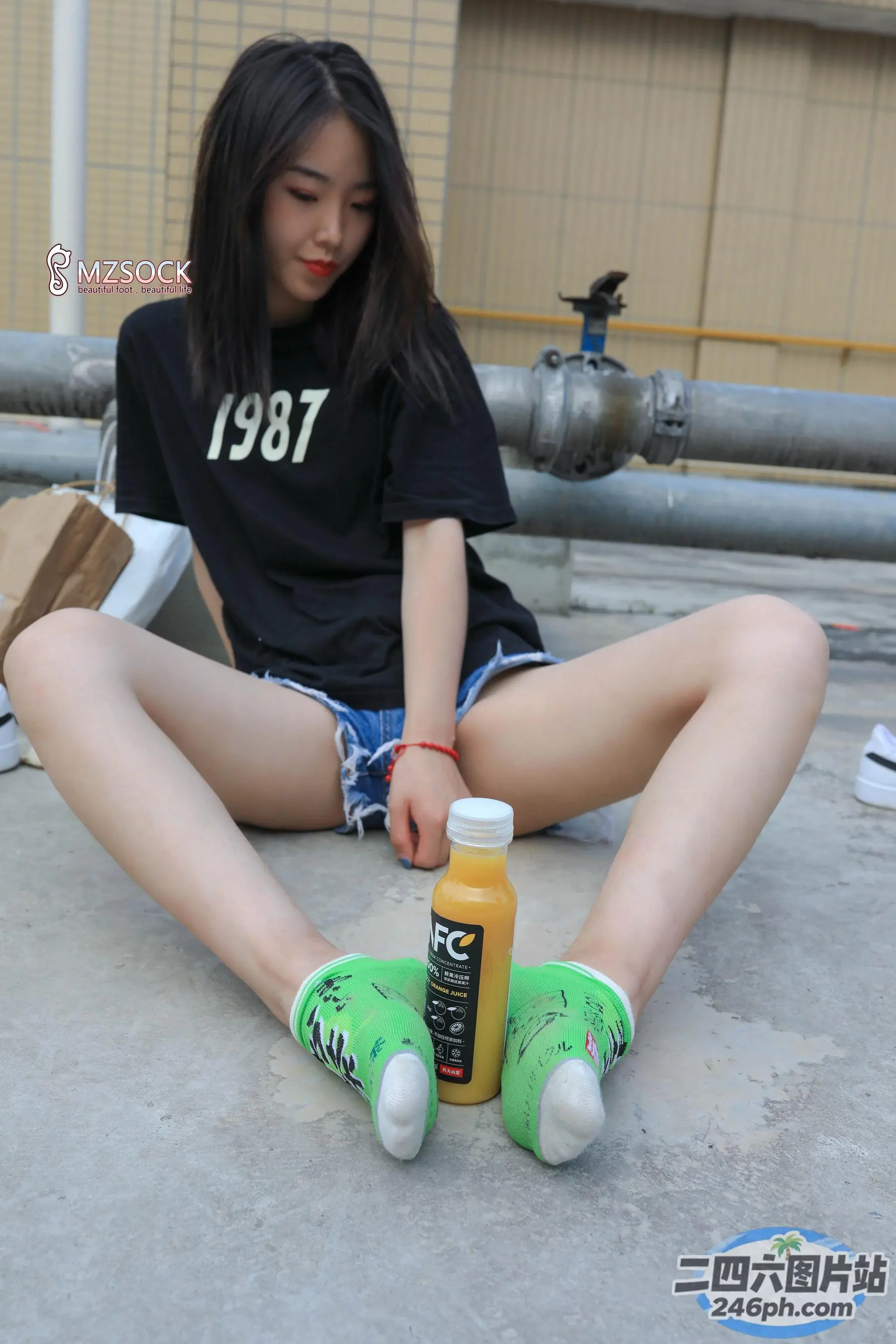 地上坐着一个女人，手里拿着一瓶果汁