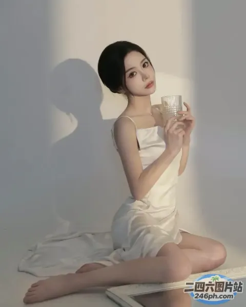 阿拉菲女子坐在地板上，手里拿着一杯水