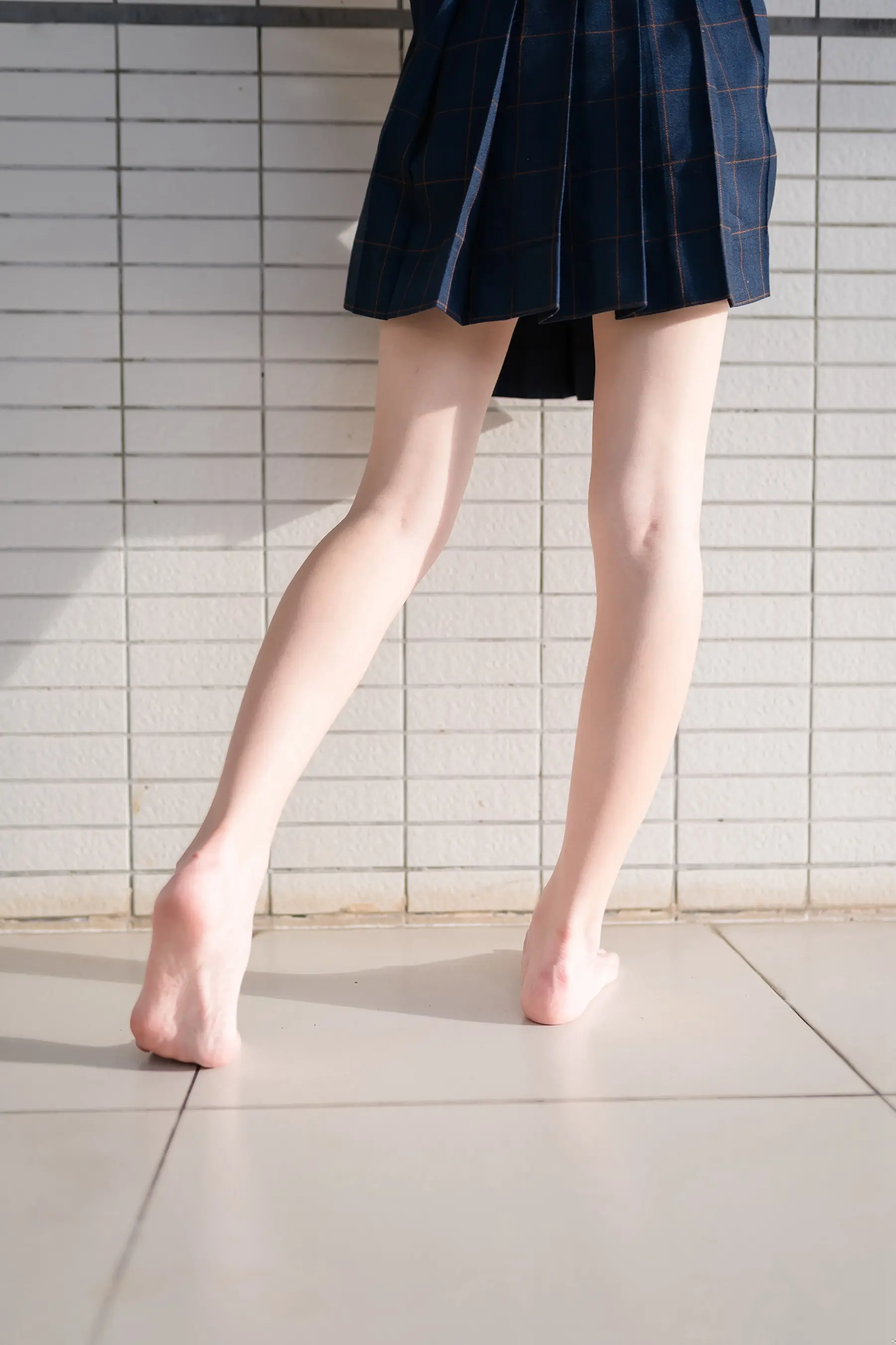 有一个穿着裙子的女人走在瓷砖地板上