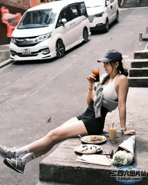坐在路边吃披萨、喝饮料的女人