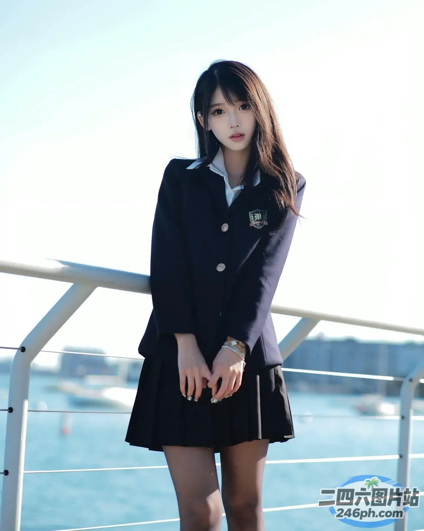穿着黑色裙子和夹克的 Arafed 女人站在栏杆上