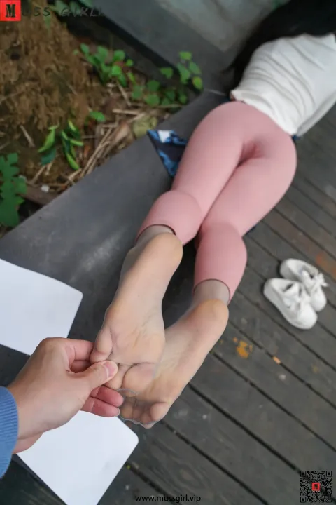 有人扶着坐在长凳上的女人的脚