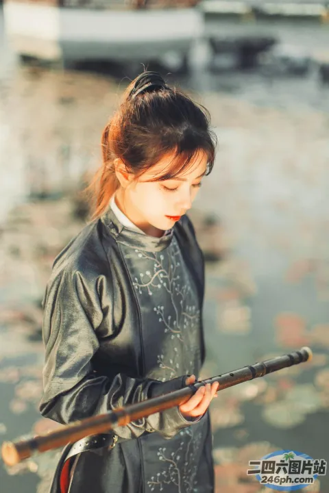 一个穿着黑色连衣裙的女人拿着一根棍子的特写