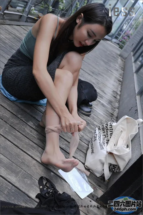 阿拉菲女人坐在木甲板上系鞋带