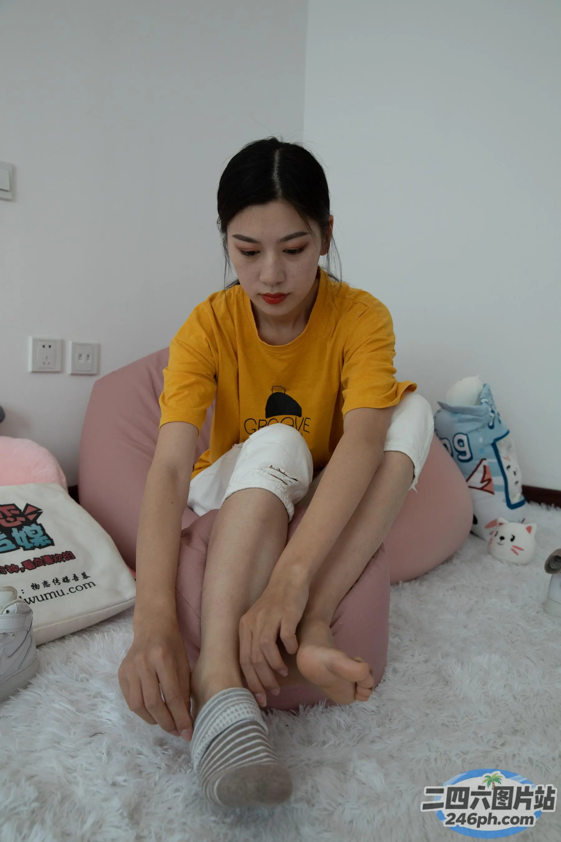 有一个女人坐在豆袋椅上，双腿交叉