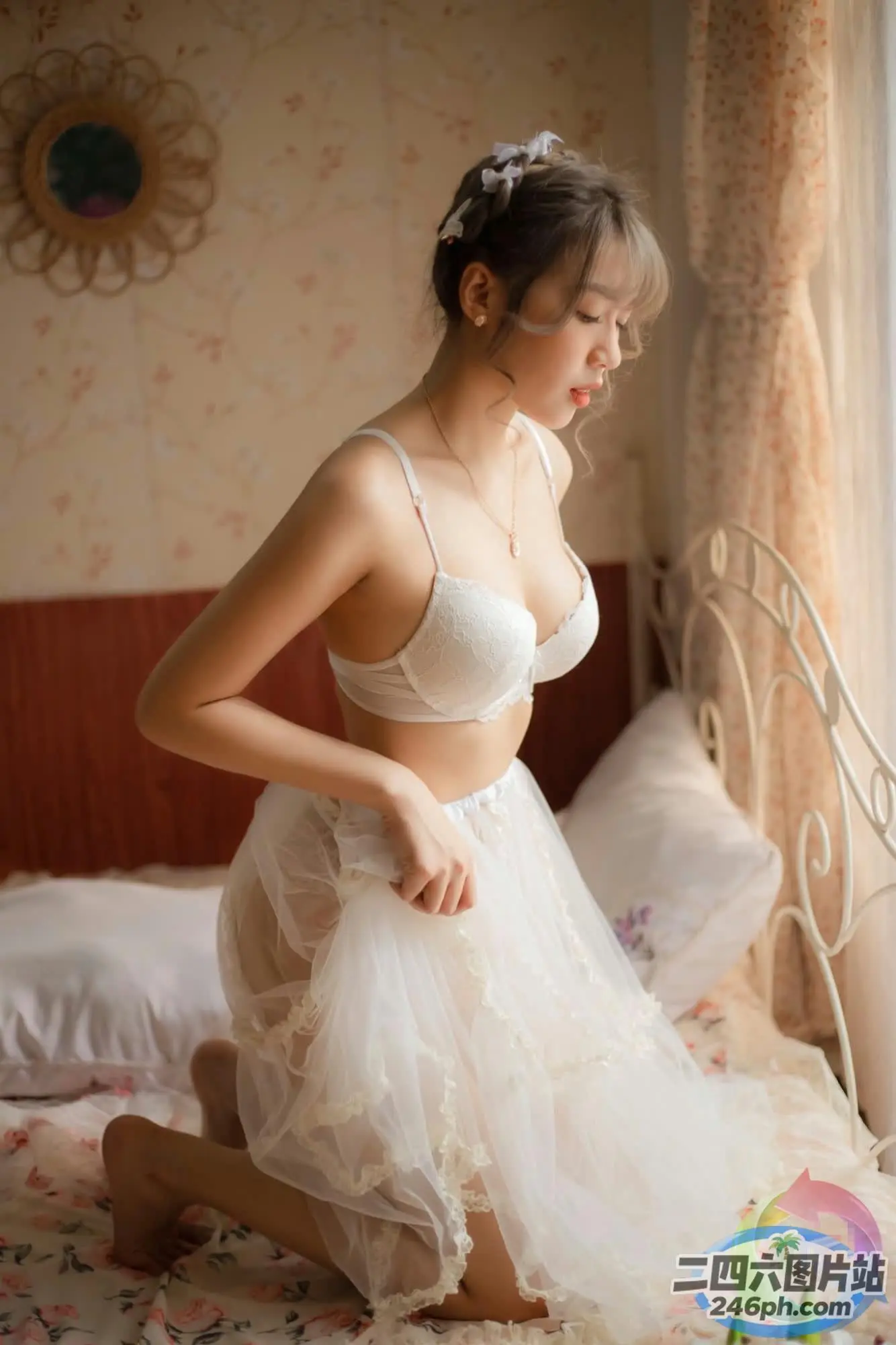 床上坐着一个穿着白色连衣裙的女人