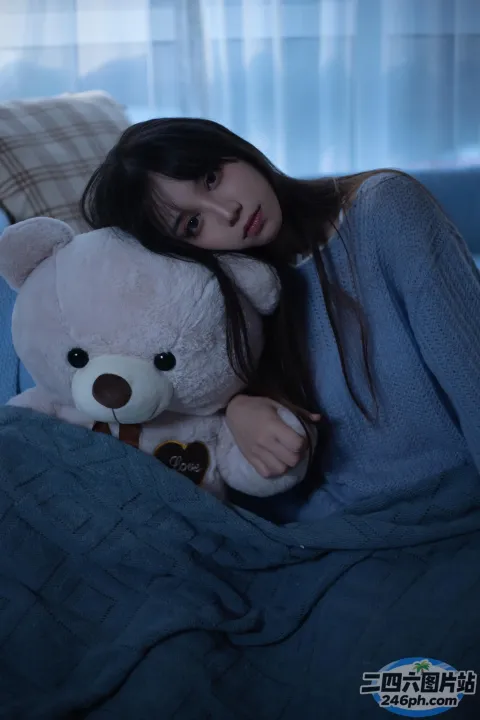 阿拉夫德女人坐在沙发上，手里拿着一只泰迪熊