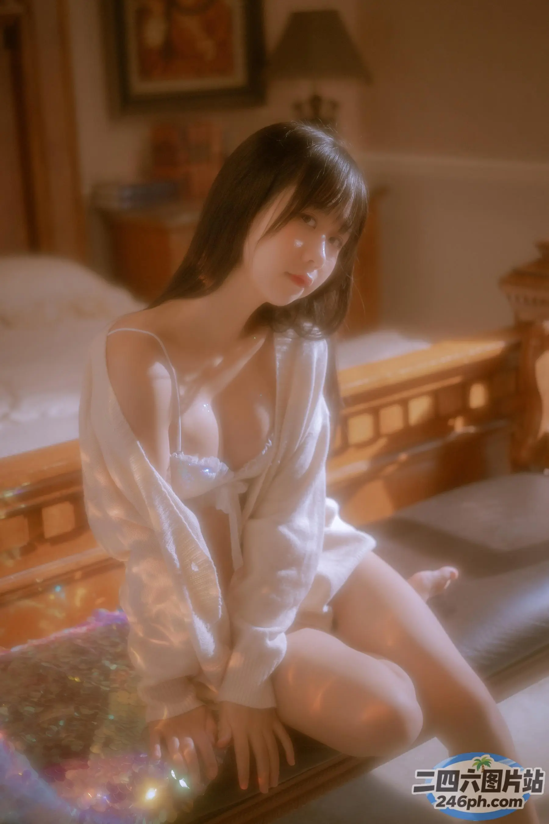 床上坐着一个穿着白衬衫的女人
