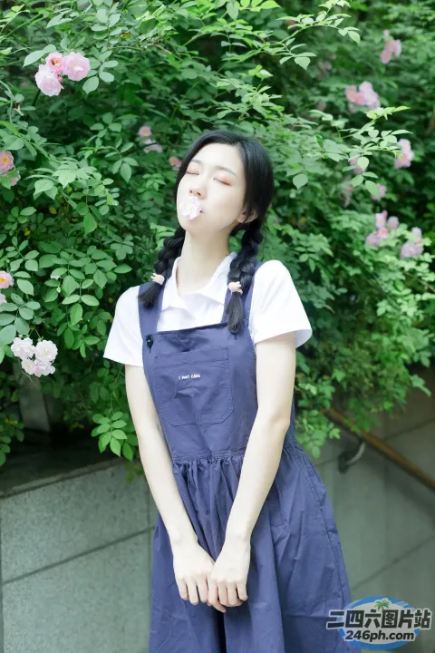 有个女人站在开花的灌木丛前