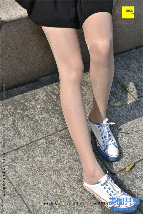 人行道上有一个穿着白色和蓝色鞋子的女人