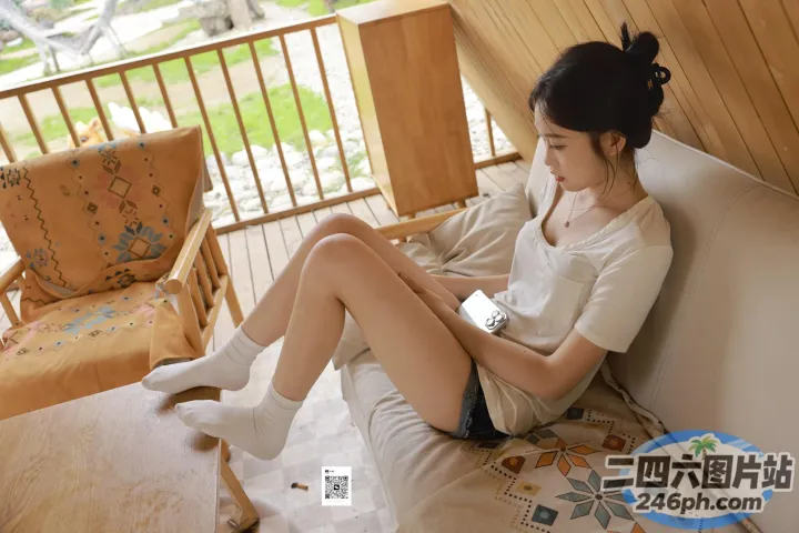 有个女人坐在沙发上，拿着遥控器