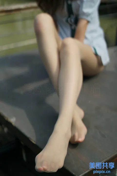 有个女人坐在长凳上，双腿交叉