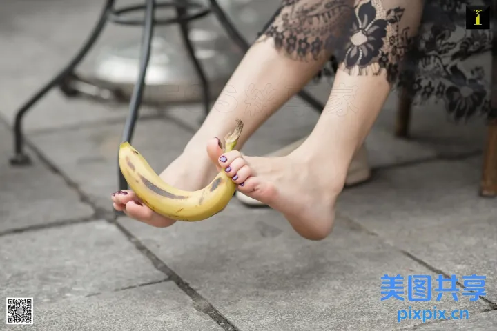 有一个女人坐在椅子上，手里拿着一根香蕉