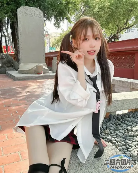 有个女人坐在石凳上，手里拿着手机