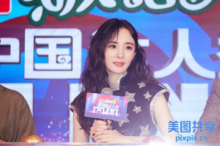 有一个女人拿着麦克风和一个牌子