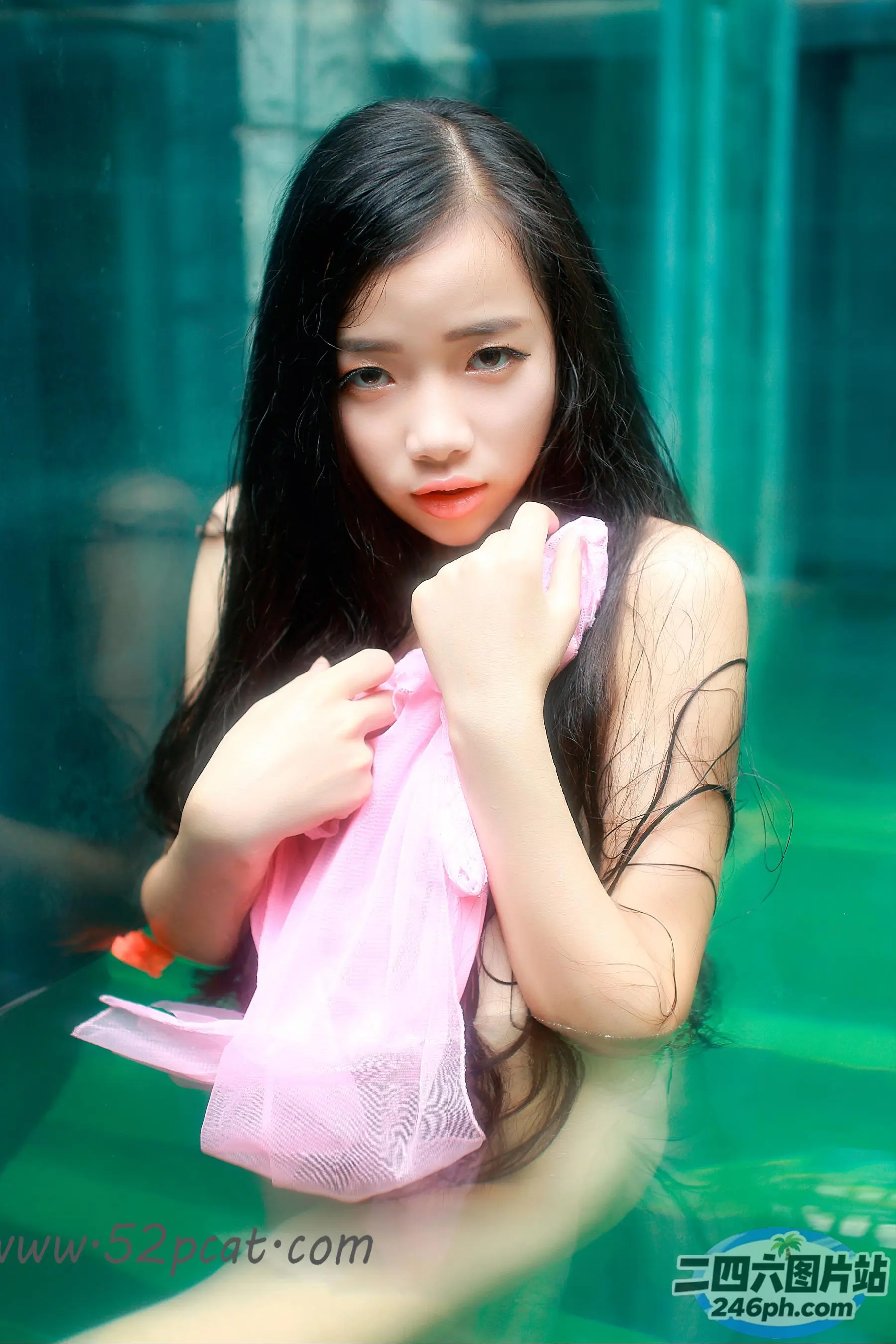拿着毛巾在游泳池里的 arafed 亚洲女人