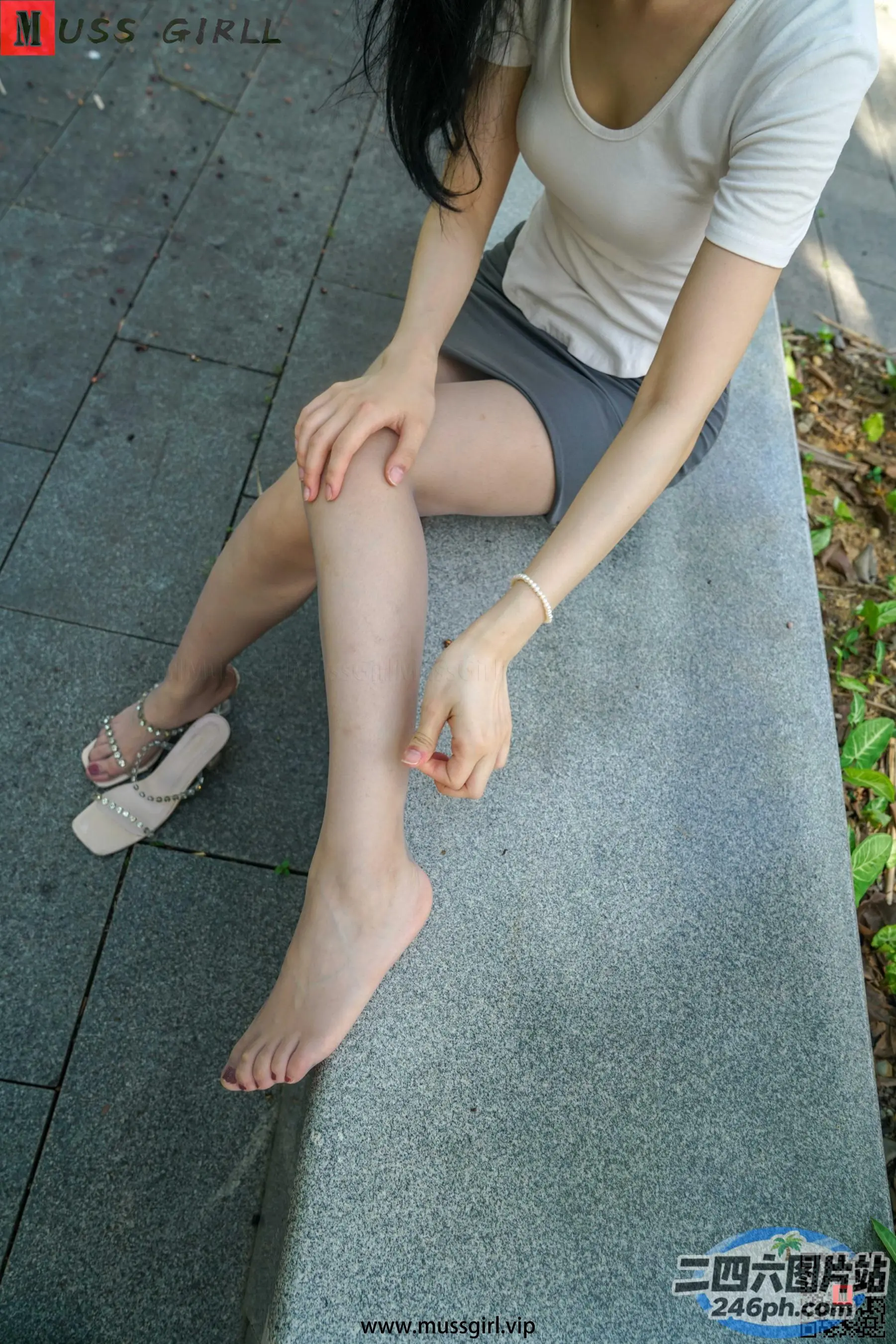 有个女人坐在长凳上，双腿交叉