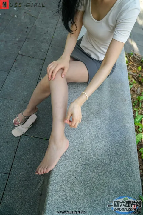 有个女人坐在长凳上，双腿交叉