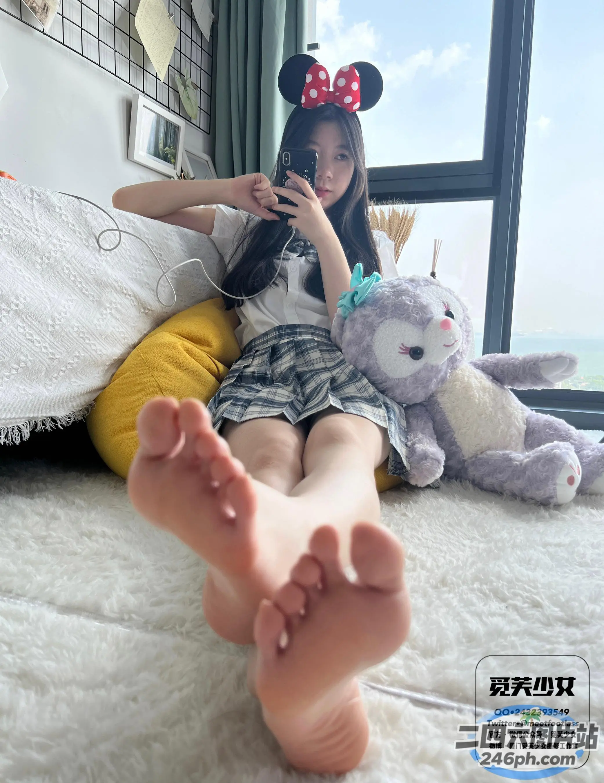 阿拉夫德女人坐在床上，手里拿着一个毛绒玩具和一部手机
