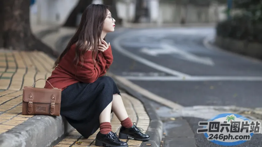 路边坐着一个女人，拎着包