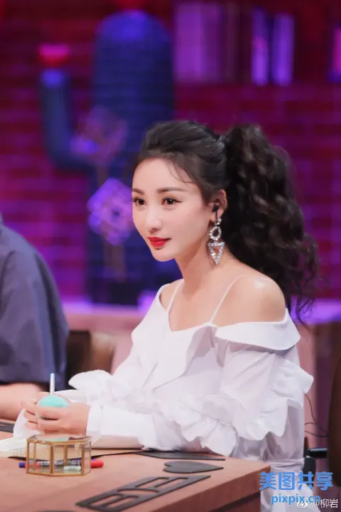 阿拉夫女人坐在桌子旁，手里拿着笔