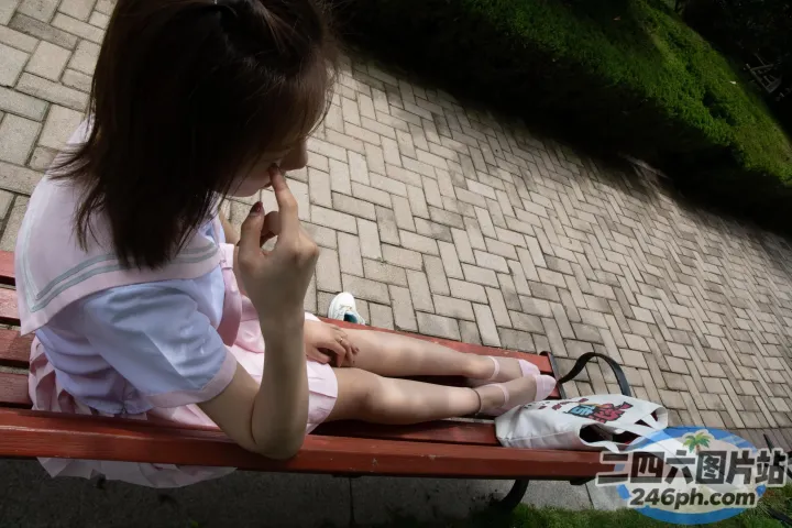 有个女人坐在长凳上，手里拿着手机