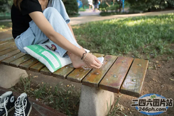 有个女人坐在长凳上，手里拿着一本书
