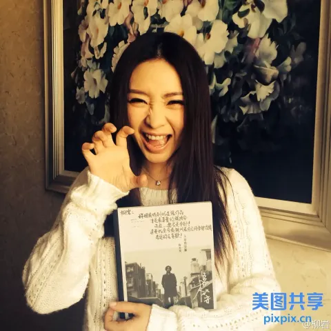 微笑的女人在城市图片前拿着一本书