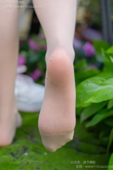 在绿色表面上行走的女人的 arafed 脚