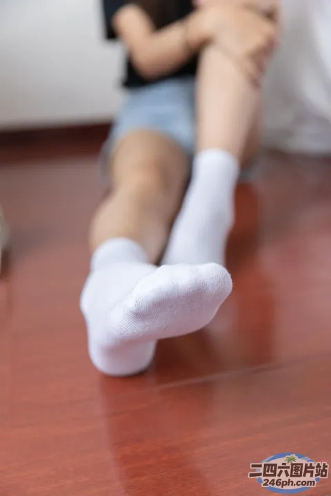 有一个女人坐在地板上，双腿交叉