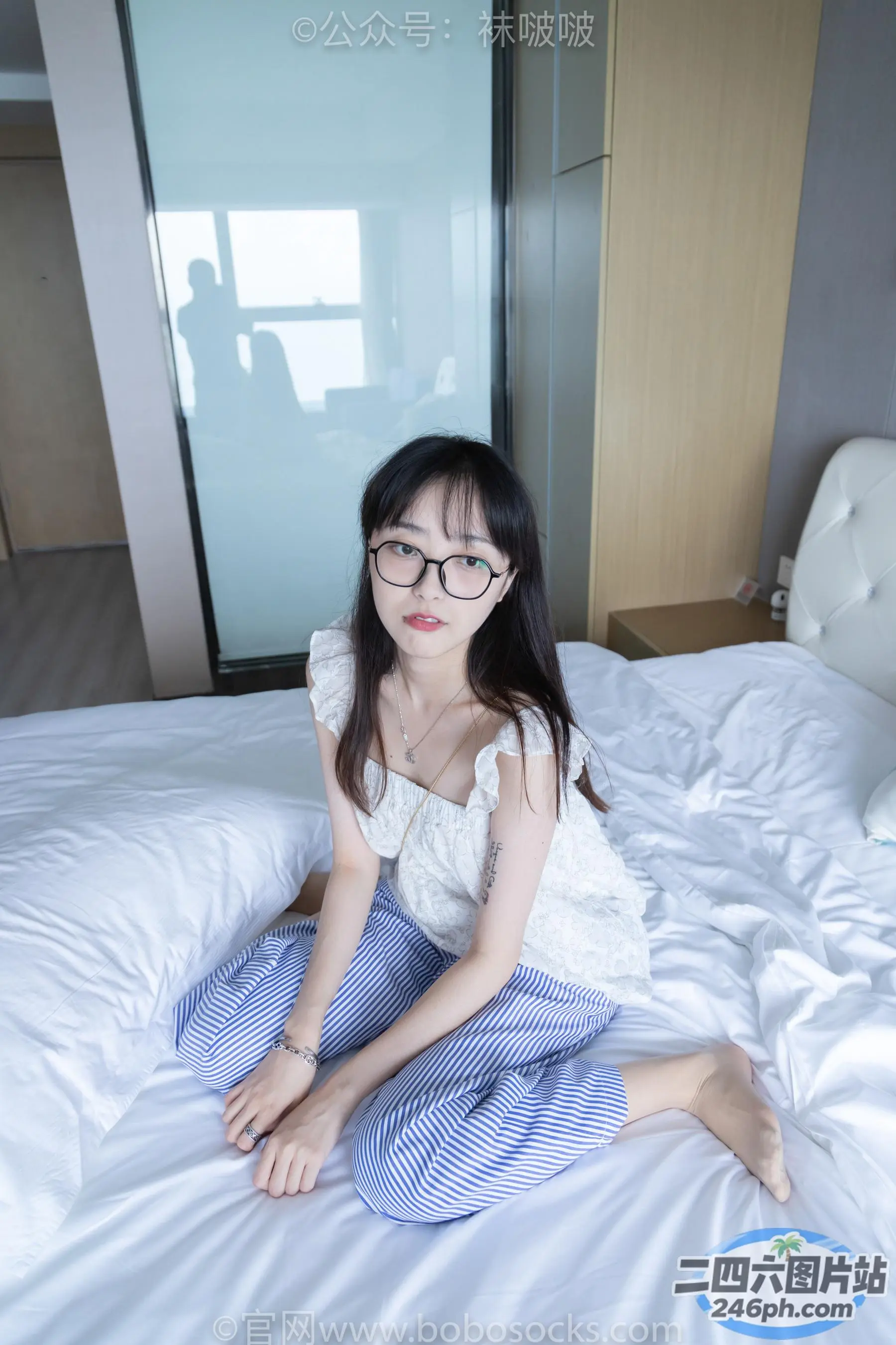 戴着一副眼镜坐在床上的亚洲女性