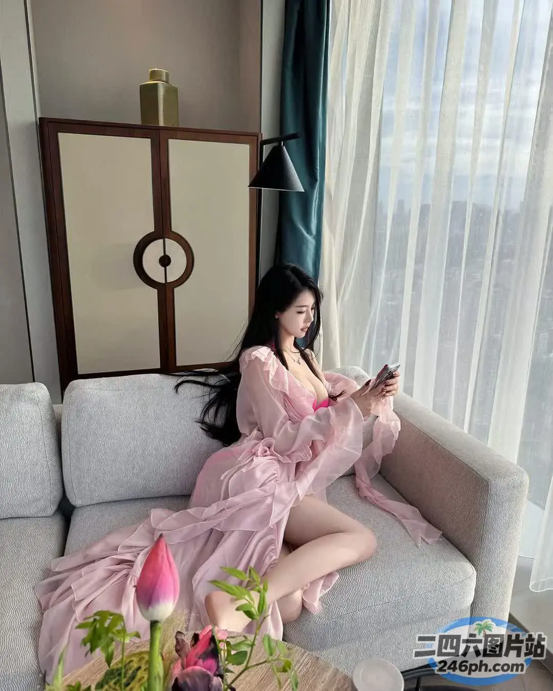 穿着粉红色连衣裙的女人坐在沙发上看书