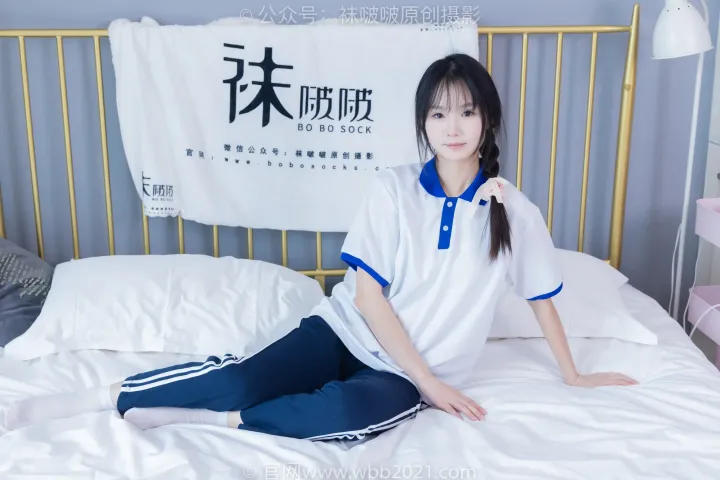 阿拉夫德亚洲妇女坐在床上，穿着白色和蓝色的衬衫