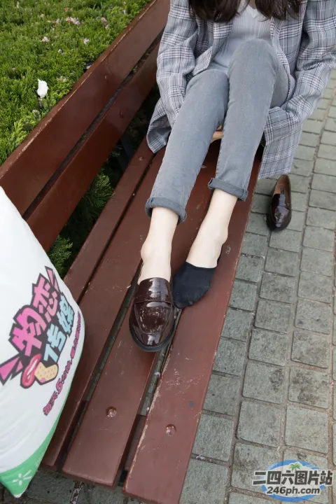 有个女人坐在长凳上，脚踩着袋子