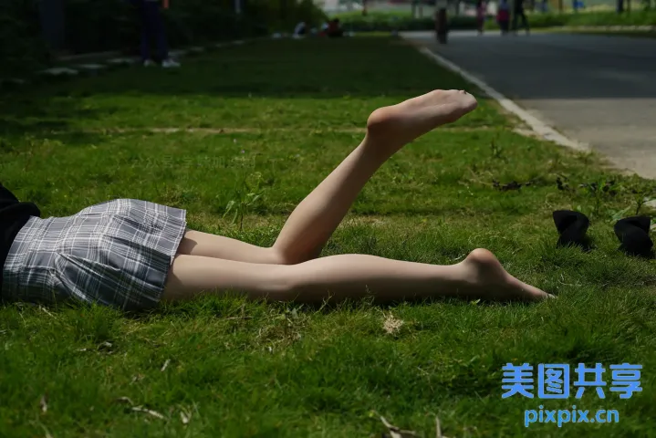 有个女人躺在草地上，双腿抬起