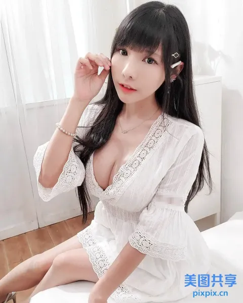 一个穿着白色连衣裙坐在床上的女人的特写