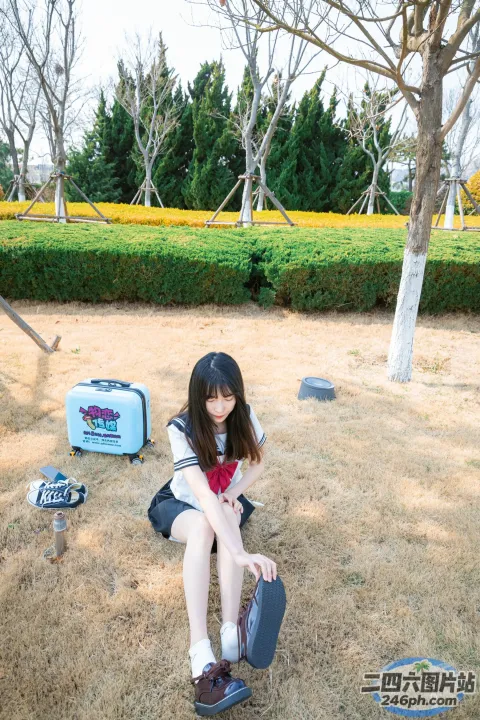 地上坐着一个女孩，手里拿着滑板