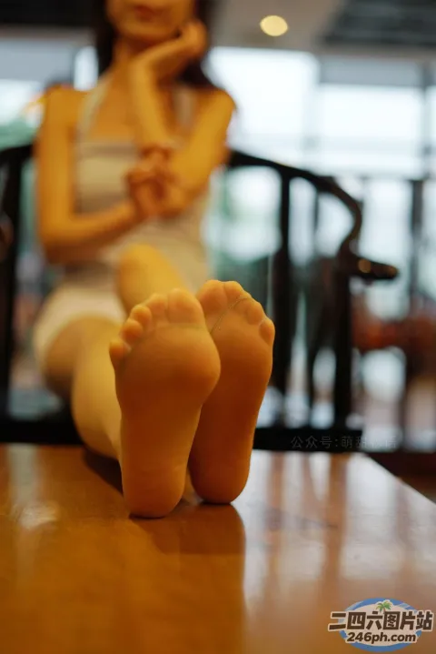有一个女人坐在桌子上，双脚抬起