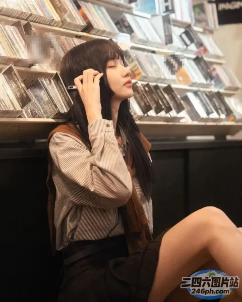 在商店里坐在地板上用手机通话的女人