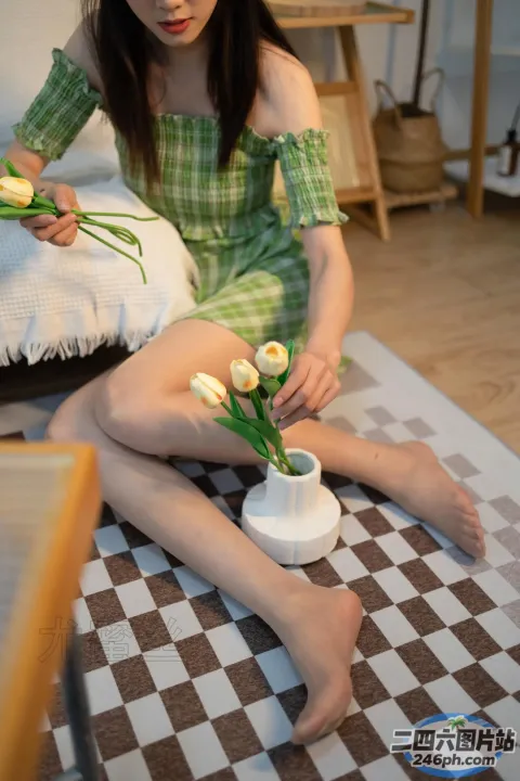 地板上坐着一个女人，手里拿着一瓶花