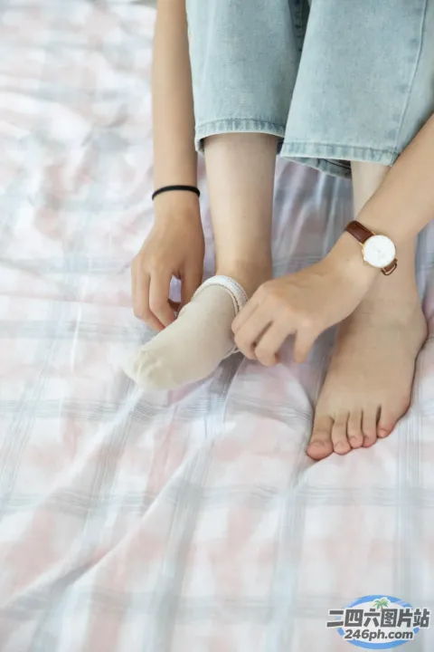 有人拿着一双袜子坐在床上