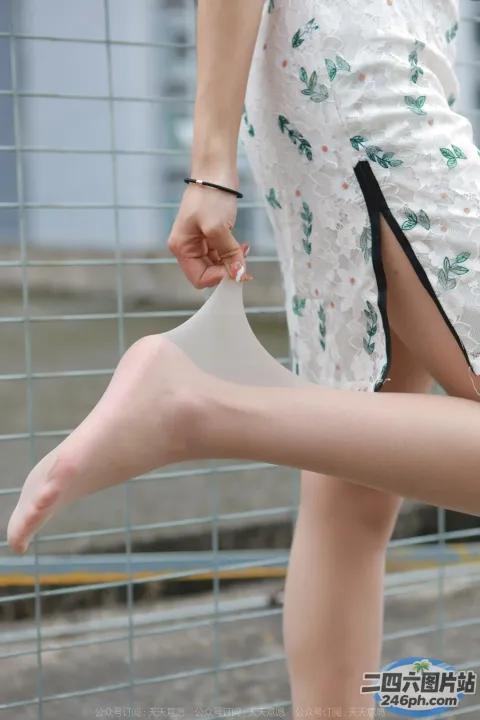 有个女人站在栅栏上，双腿交叉