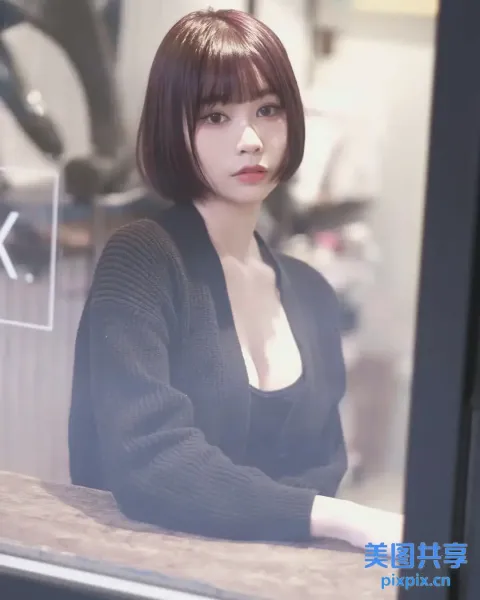 一位女士坐在桌子旁，手里拿着一杯咖啡