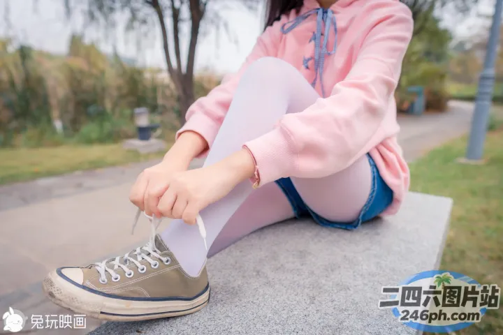 坐在长凳上系鞋带的 Araffed 女人