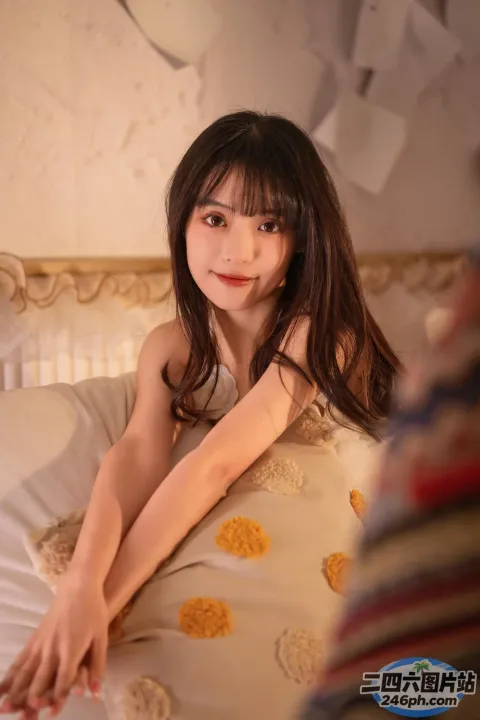 有一个年轻女孩躺在床上，手里拿着一个枕头