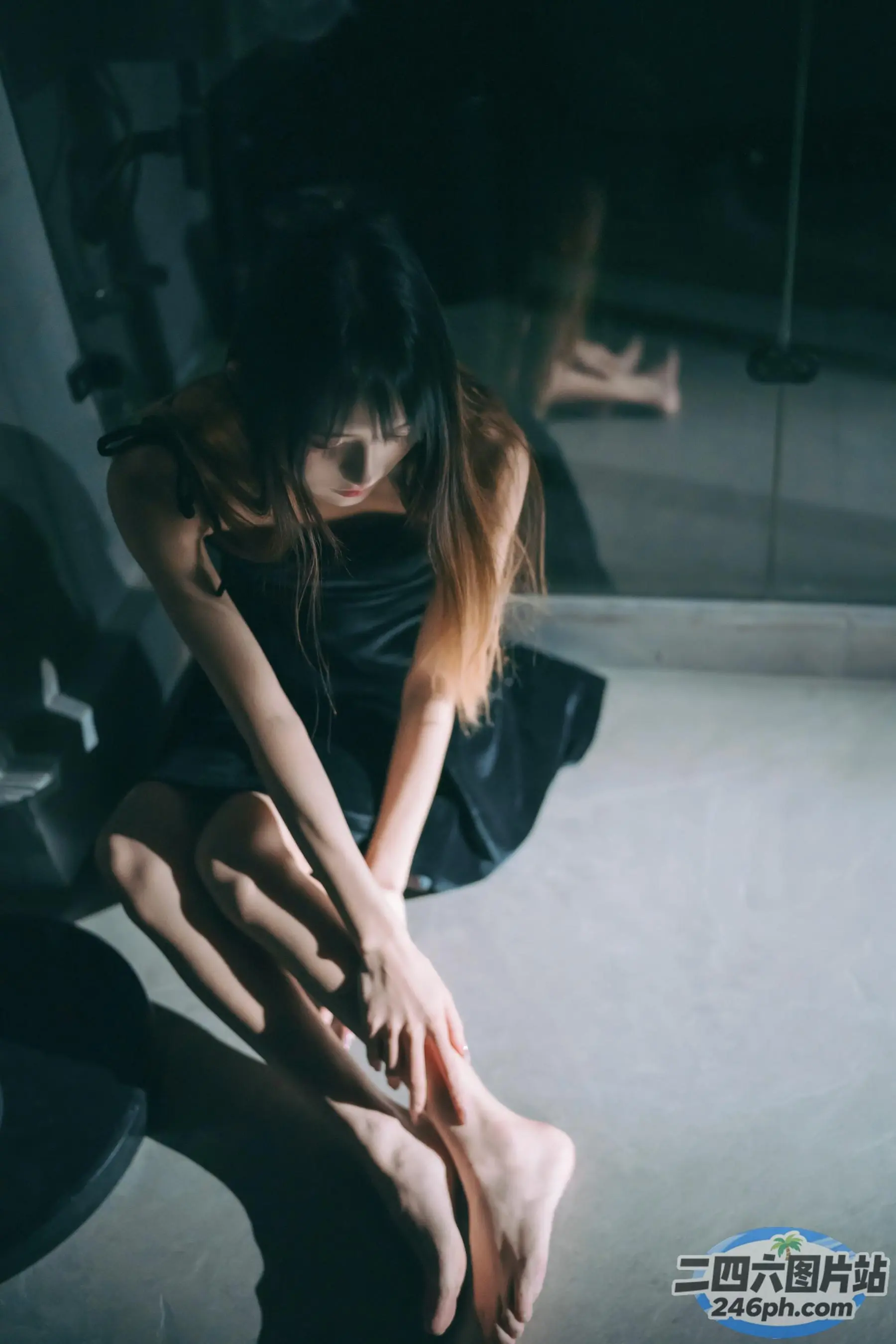 有一个女人坐在地板上，双腿交叉