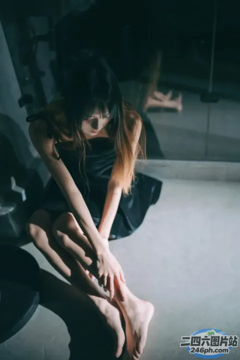 有一个女人坐在地板上，双腿交叉