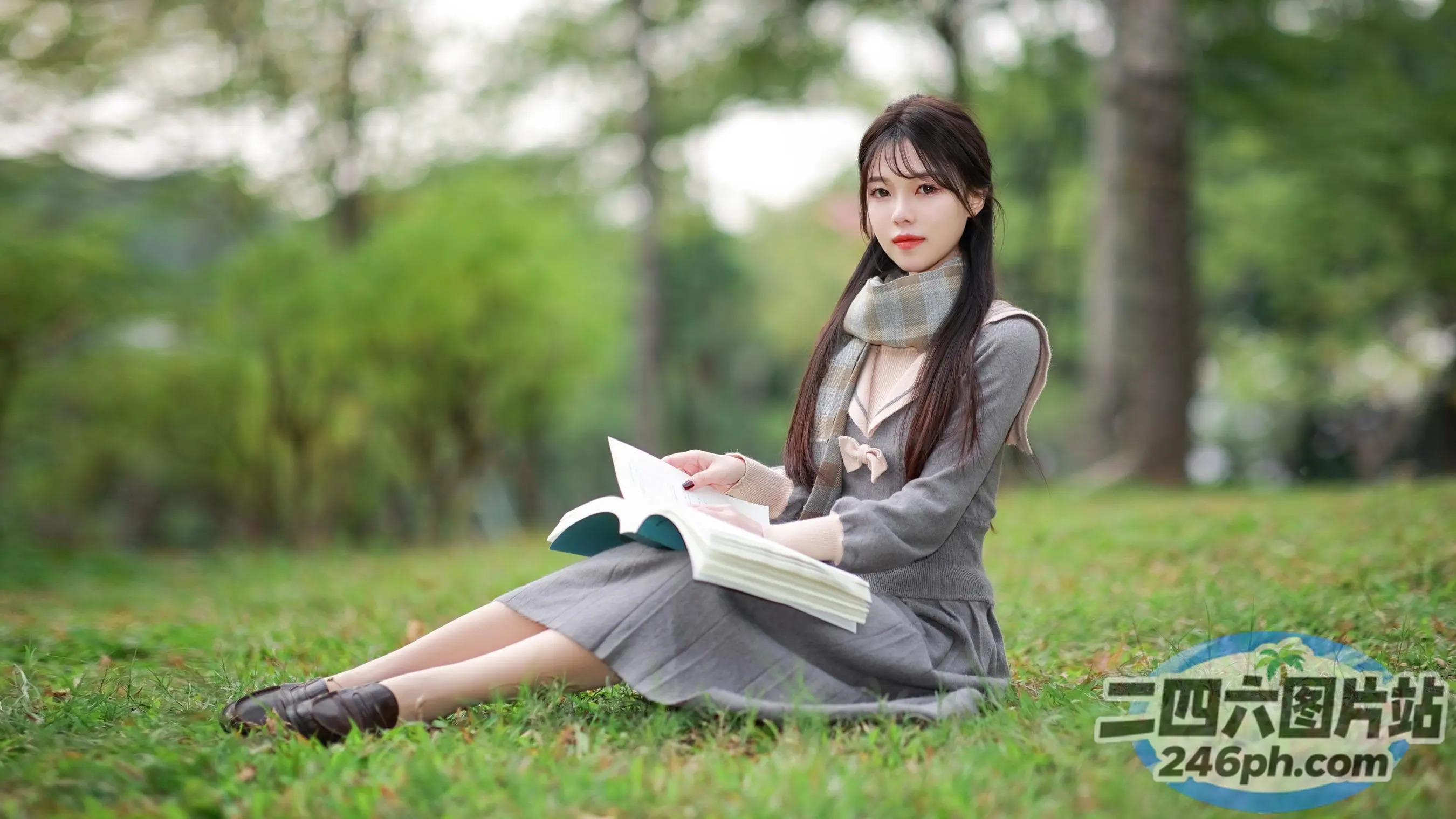 阿拉菲德亚洲妇女坐在草地上看书