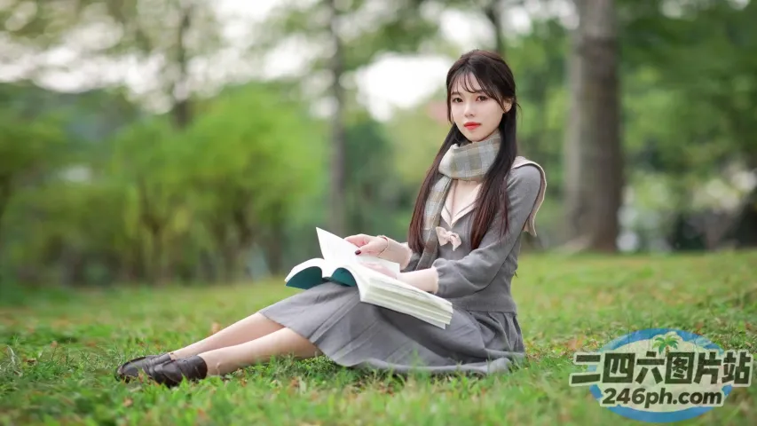 阿拉菲德亚洲妇女坐在草地上看书
